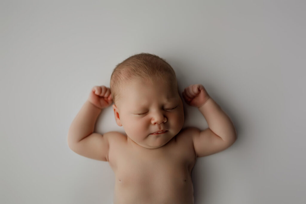 newborn baby settled after feeding before photo session